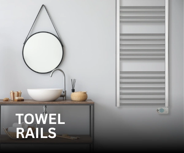 A chrome Elnur TBCK towel rail installed on a bathroom wall, with a sink and mirror to the left of it. The text 'Towel Rails' is in front of it.